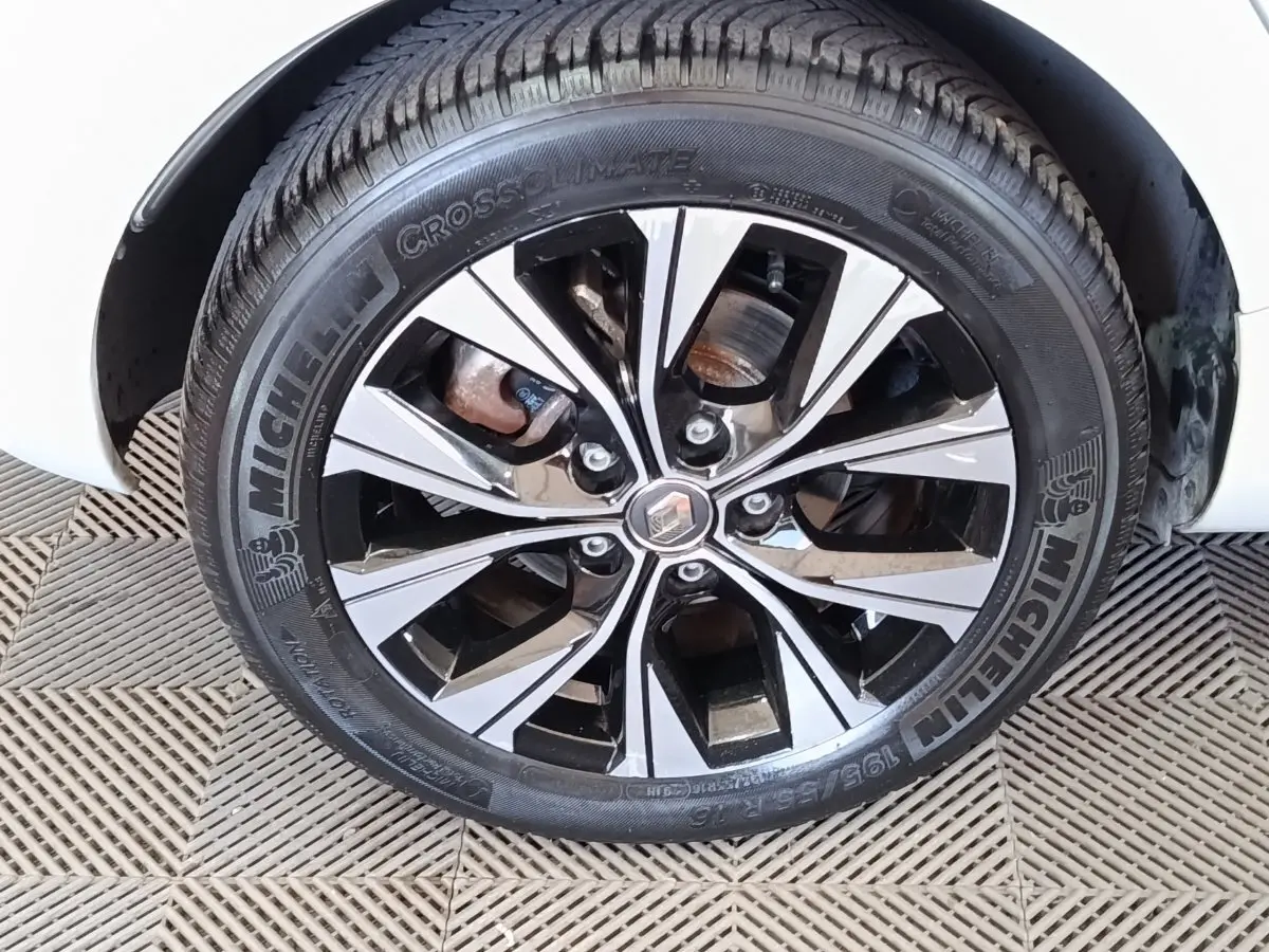 Gros plan sur la roue avant droite de la Renault ZOE blanche, jante alliage bicolore et pneu Michelin visible.