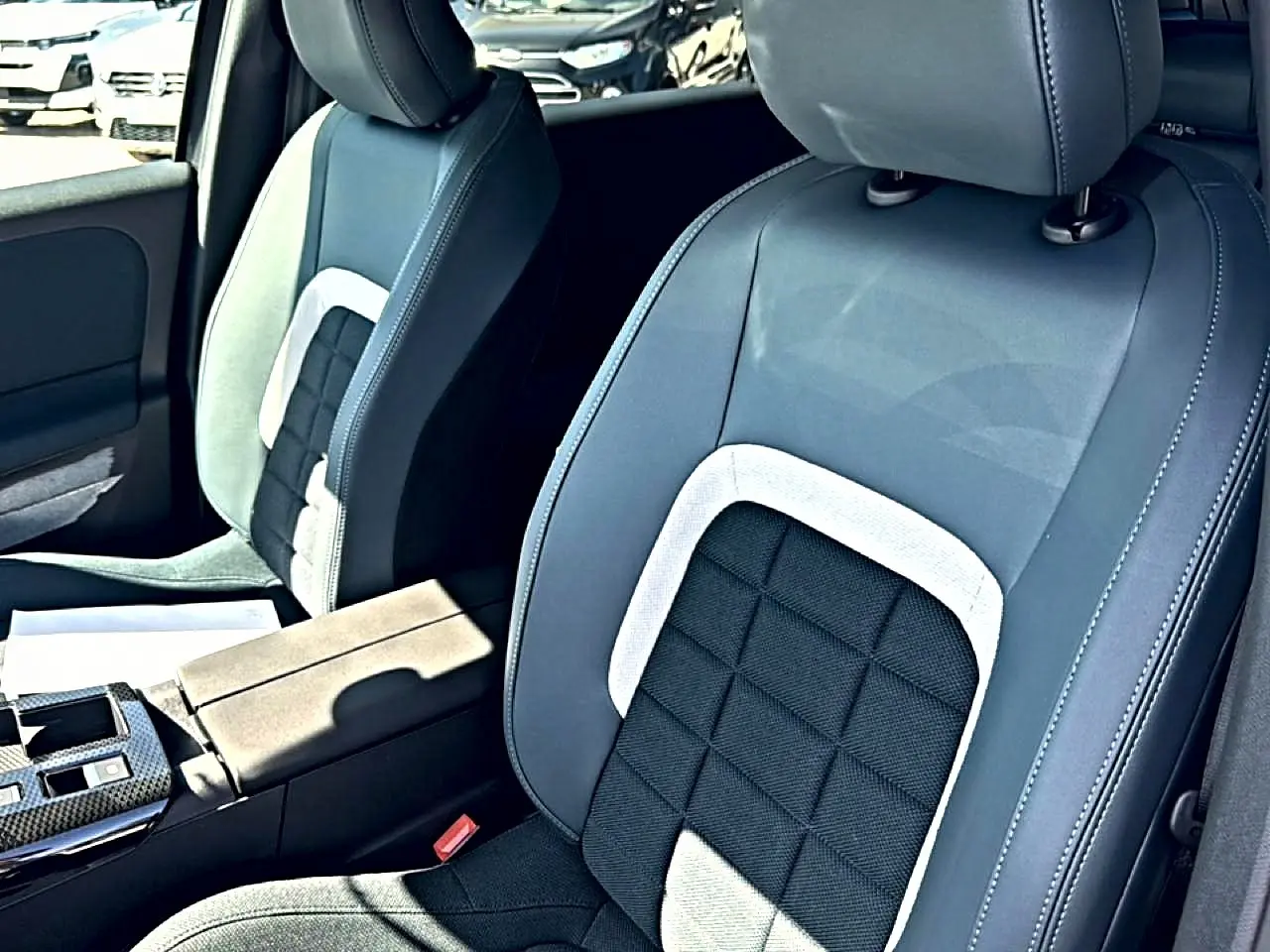 Gros plan sur les sièges avant bi-ton gris et noir du Citroën C5 Aircross avec accoudoir central visible.