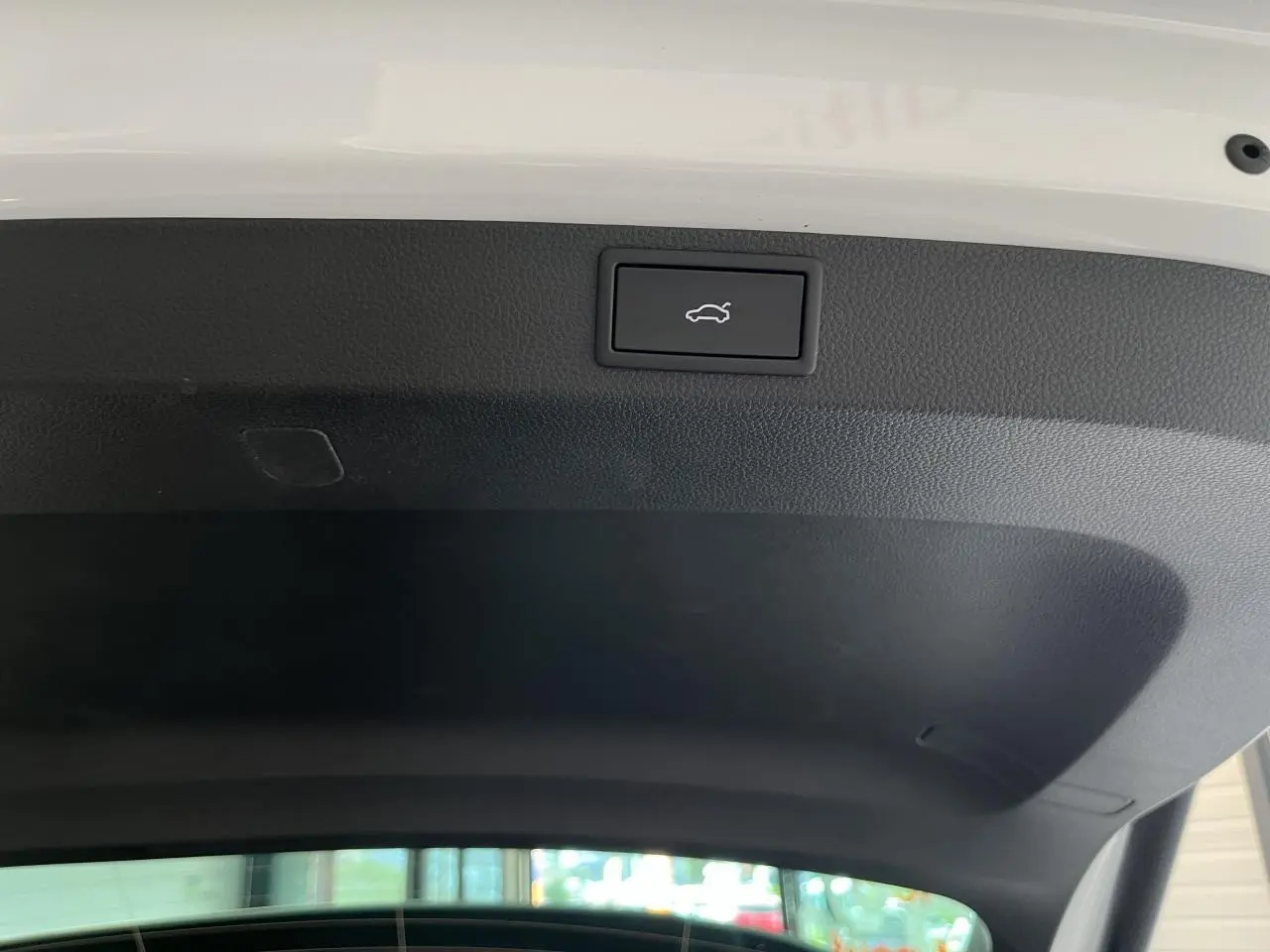 Bouton d'ouverture électrique du hayon sur l'intérieur du coffre noir d'un Skoda Karoq blanc 2025 Sportline