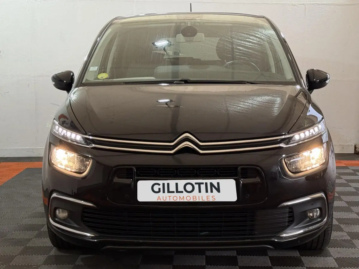 Vue frontale d'une Citroën C4 Spacetourer noire avec feux allumés et logo double chevron visible sur la calandre.