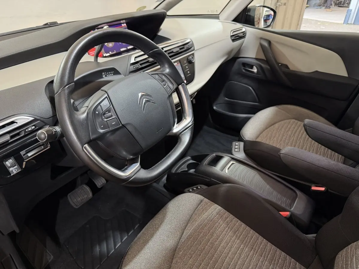 Vue intérieure côté conducteur de la Citroën C4 Spacetourer 2020, volant cuir noir et sièges bi-ton beige et noir.