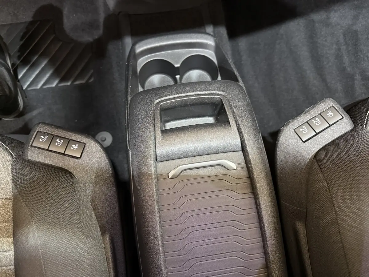 Vue plongeante sur la console centrale arrière noire du Citroën C4 Spacetourer avec commandes sièges chauffants.