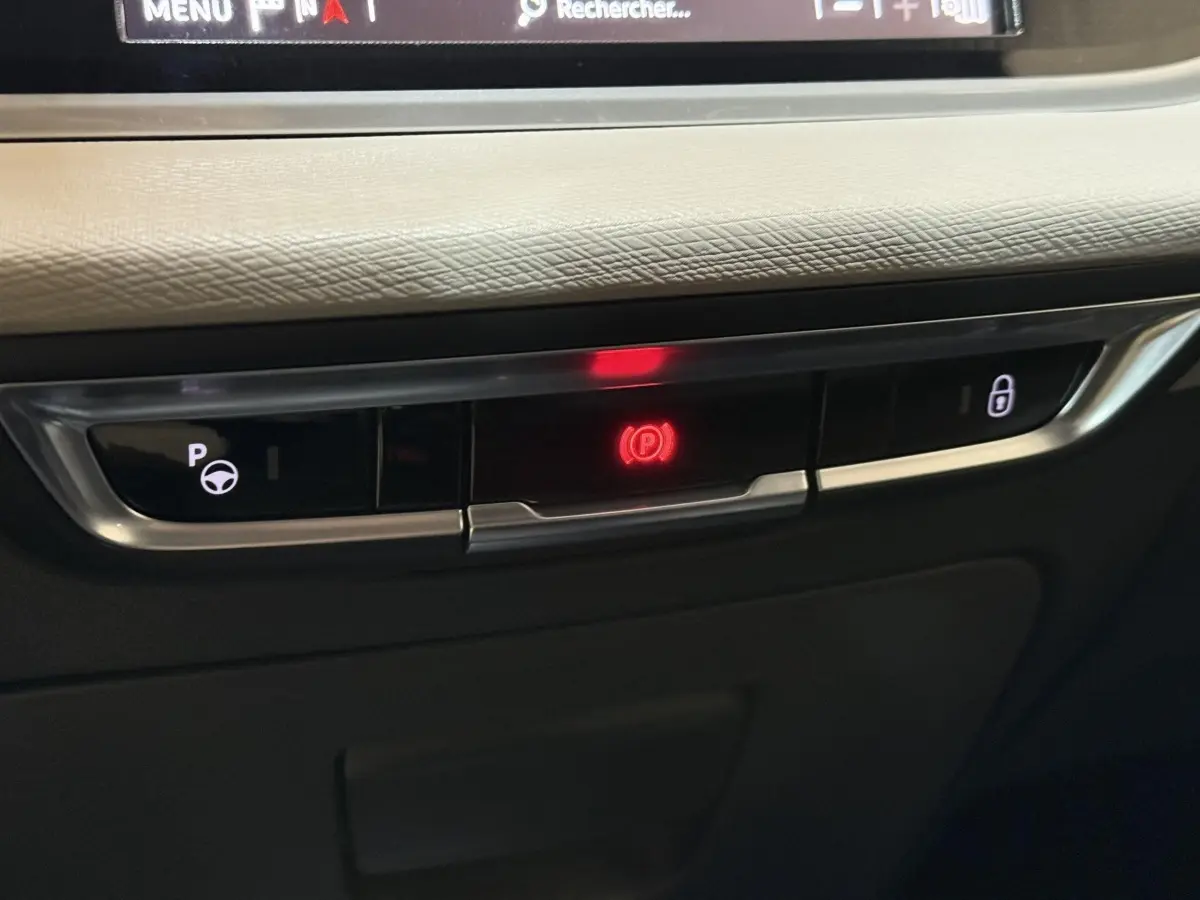 Gros plan sur les commandes de frein à main électrique et verrouillage central du tableau de bord du Citroën C4 Spacetourer noir.