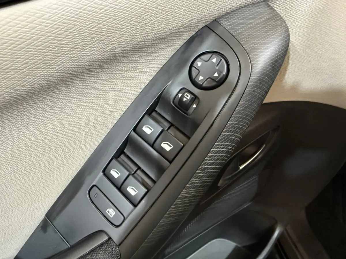 Détail des commandes de lève-vitres et réglage des rétroviseurs sur la porte intérieure côté conducteur du Citroën C4 Spacetourer noir.