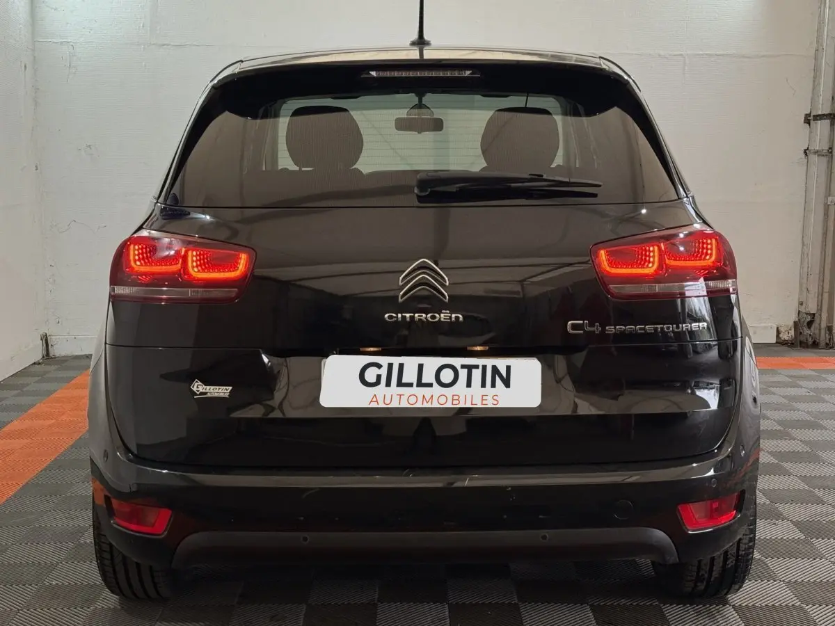 Vue arrière d'un Citroën C4 Spacetourer noir 2020 avec feux LED allumés dans un garage.