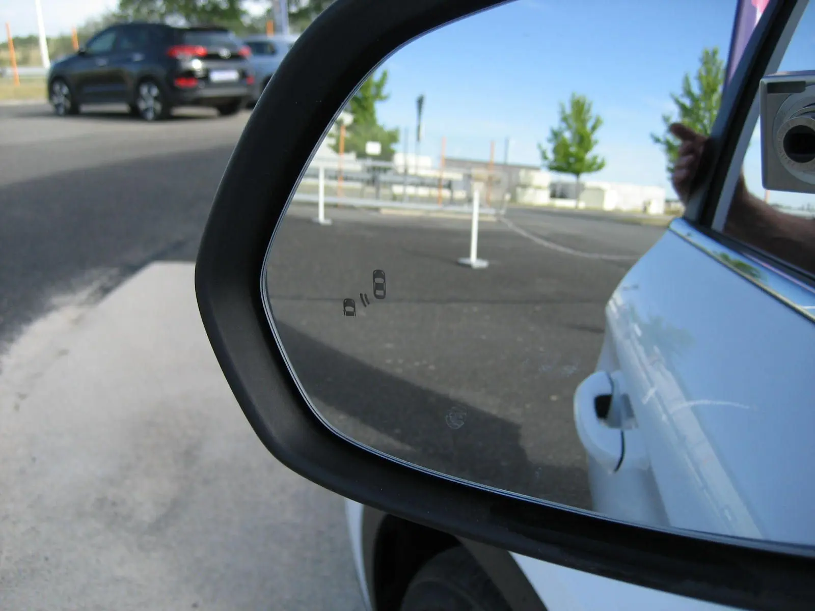 Rétroviseur côté droit du MG ZS blanc 2026, avec reflet du véhicule et vue partielle d’une voiture noire à l’arrière.
