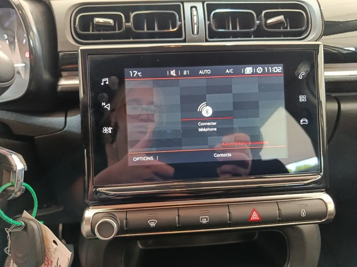 Vue rapprochée de l’écran tactile central noir du tableau de bord de la Citroën C3 blanche, affichant la connexion Bluetooth.
