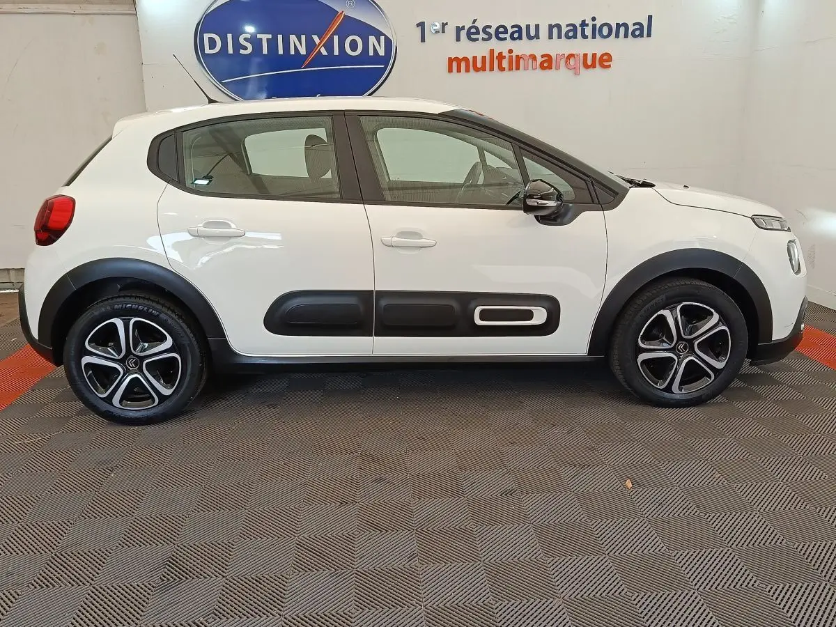 Vue latérale droite d'une Citroën C3 blanche de 2022 avec protections noires et jantes alliage distinctives.