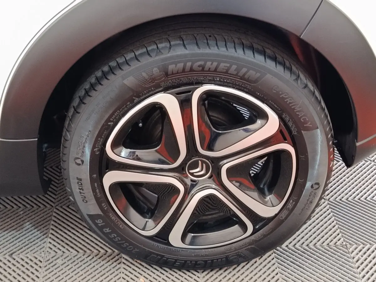 Gros plan sur la roue avant droite de la Citroën C3 blanche, avec jante alliage noire et argentée distinctive.