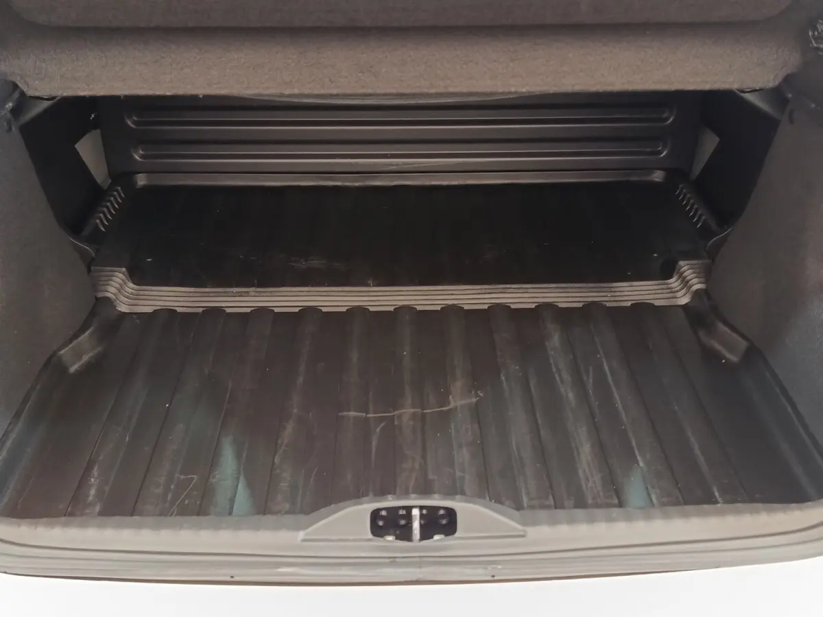 Coffre ouvert vu de face d'une Citroën C3 blanche 2022 avec tapis de protection noir.