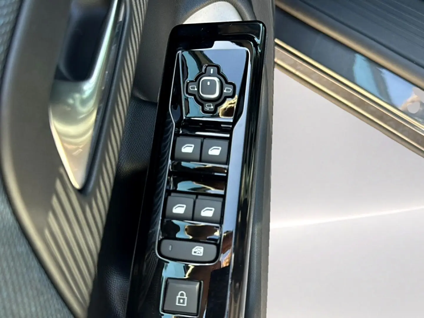 Gros plan sur les commandes de lève-vitres et rétroviseurs côté conducteur du Citroën C5 Aircross gris platinium.