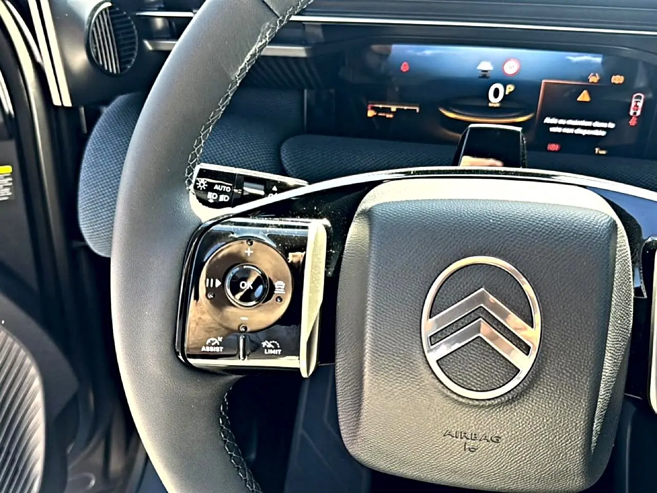 Gros plan sur le volant multifonction noir du Citroën C5 Aircross 2026 avec logo chrome et tableau de bord numérique en arrière-plan.