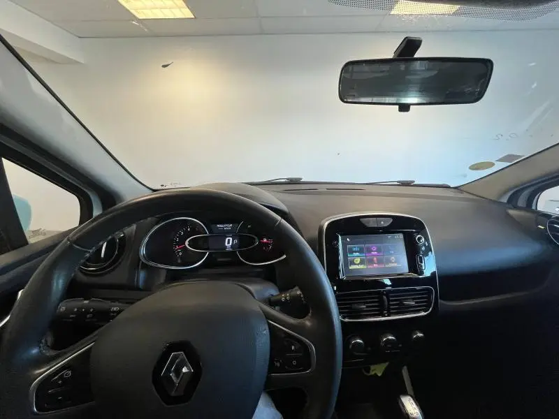 Vue intérieure avant du tableau de bord et volant noir d'une Renault Clio Estate 2019 avec écran tactile central.