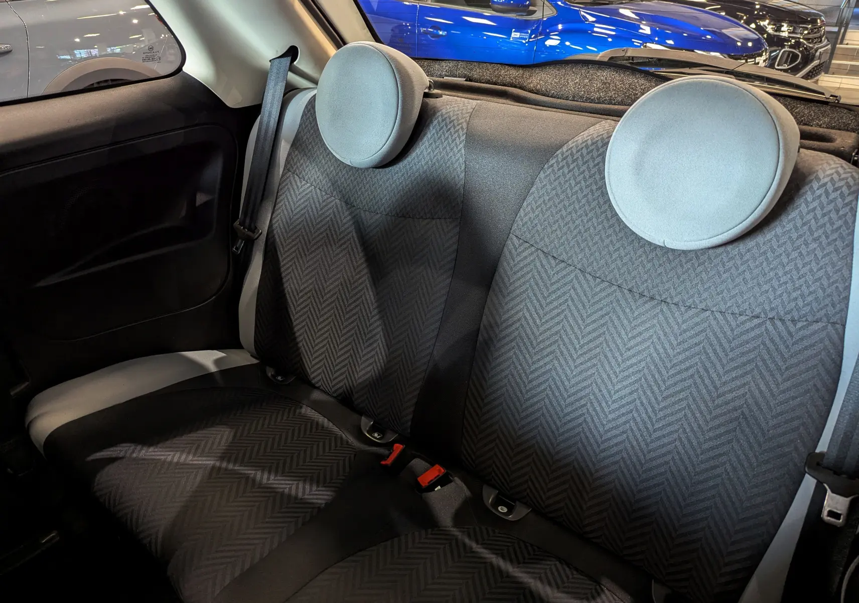 Vue intérieure arrière des sièges en tissu gris à motifs chevrons de la Fiat 500 Blanc Bossanova 2018.