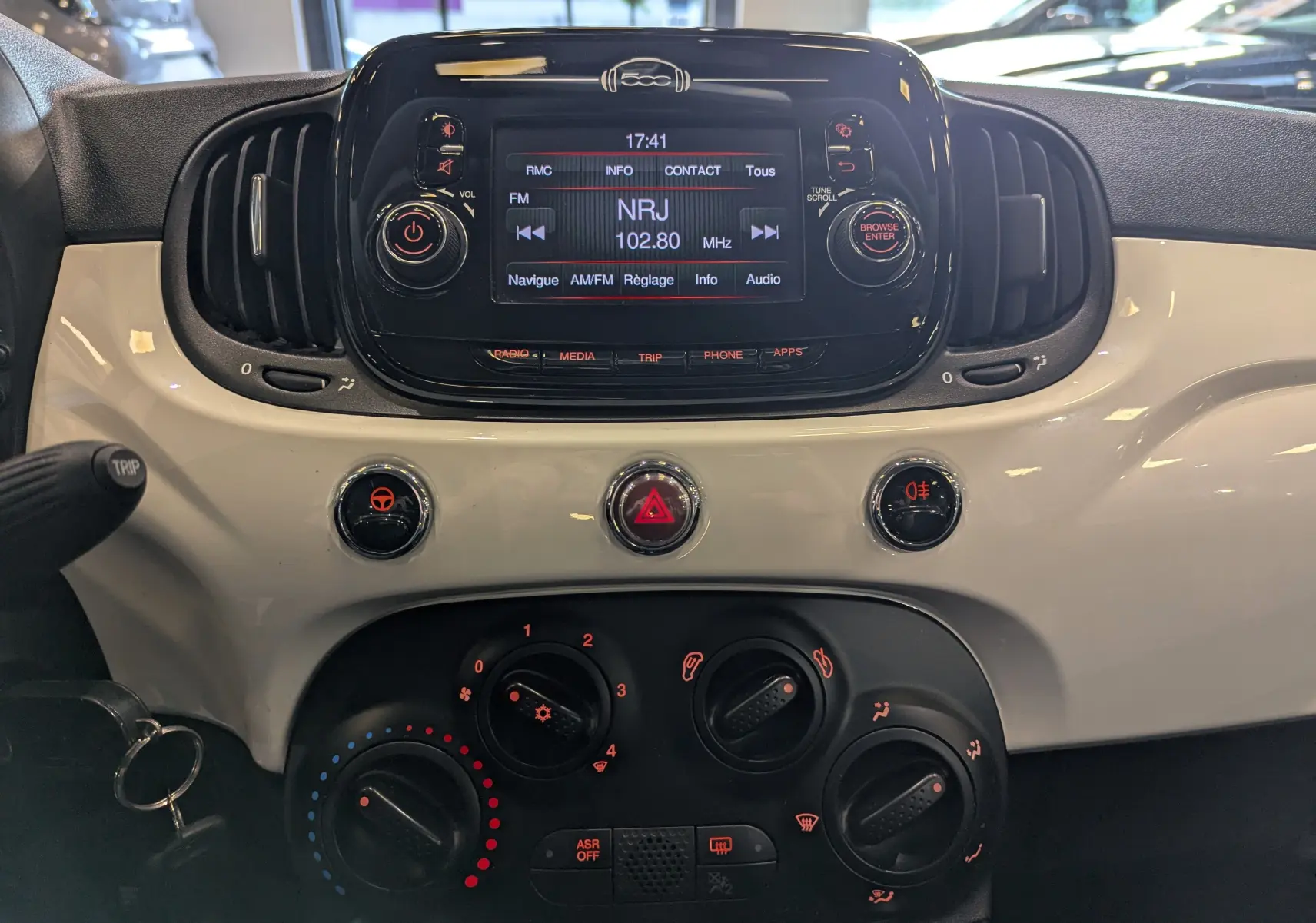 Tableau de bord intérieur de Fiat 500 blanc Bossanova, avec écran multimédia et commandes de climatisation visibles.