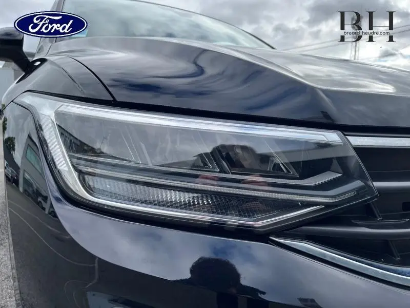 Gros plan sur le phare avant droit du Volkswagen Tiguan noir intense nacré, mettant en valeur son design LED moderne.