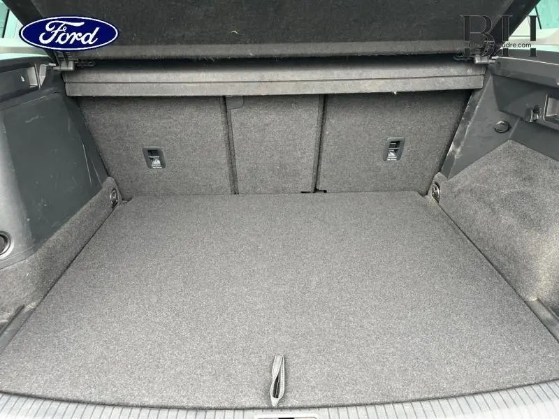 Vue intérieure du coffre spacieux et tapissé en gris d'un Volkswagen Tiguan 1.4 eHybrid noir intense nacrée.