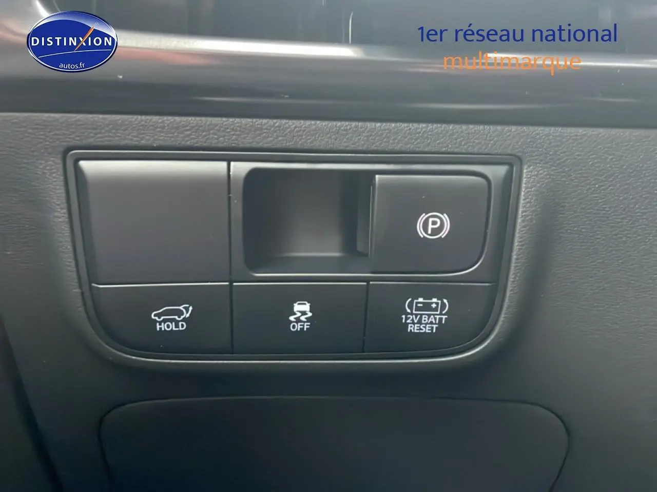 Boutons de commande du frein de stationnement et aides à la conduite sur tableau de bord noir du Hyundai Tucson gris Ecotronique.