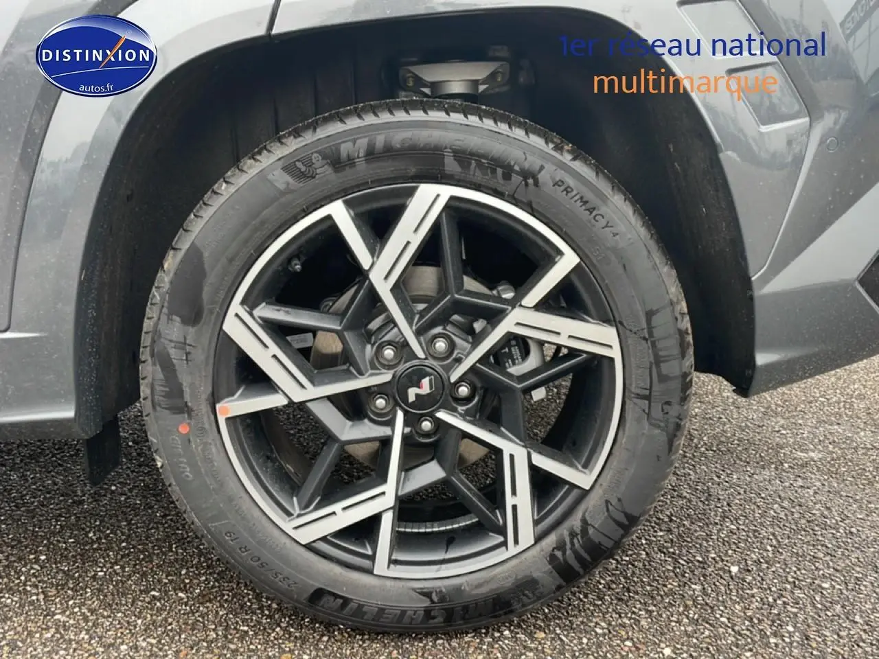 Gros plan sur la jante alliage 19 pouces design N Line en noir et argent du Hyundai Tucson gris électronique, côté avant droit.
