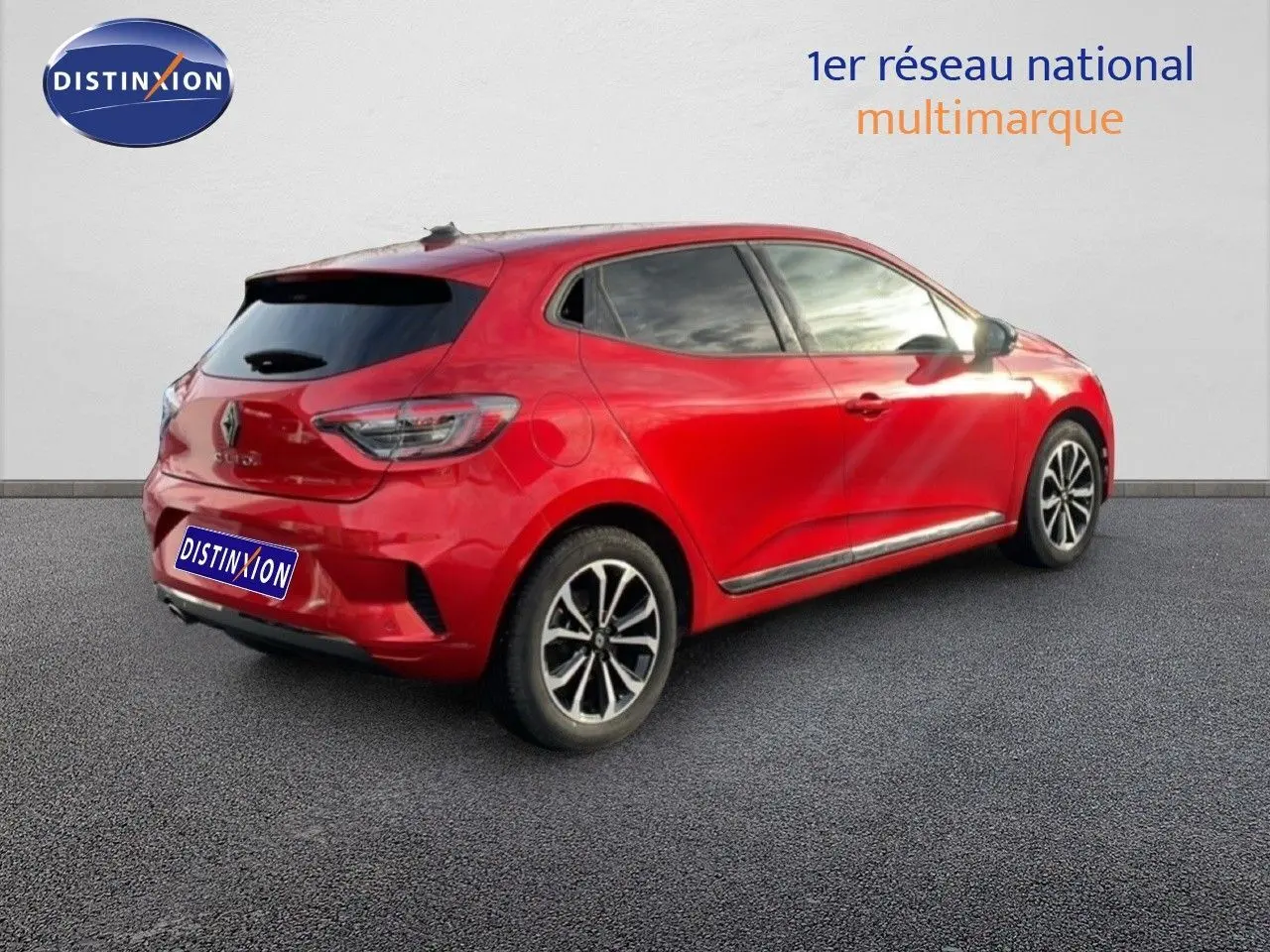 Vue 3/4 arrière droite d'une Renault Clio 2025 rouge Désir Métal avec jantes alliage et vitres teintées.