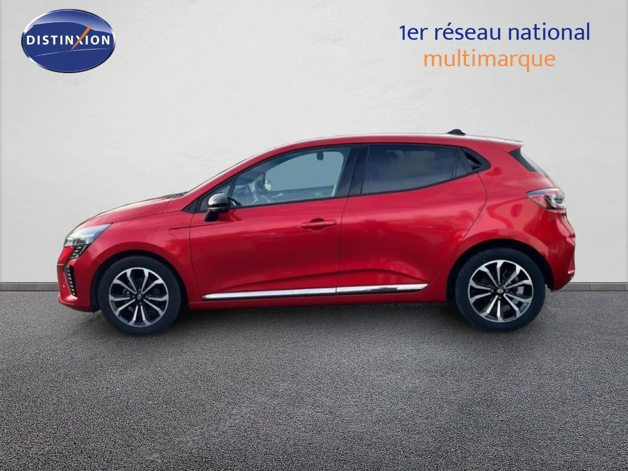 Profil droit d'une Renault Clio 2025 rouge désir métal avec jantes alliage et détails chromés sur fond neutre.