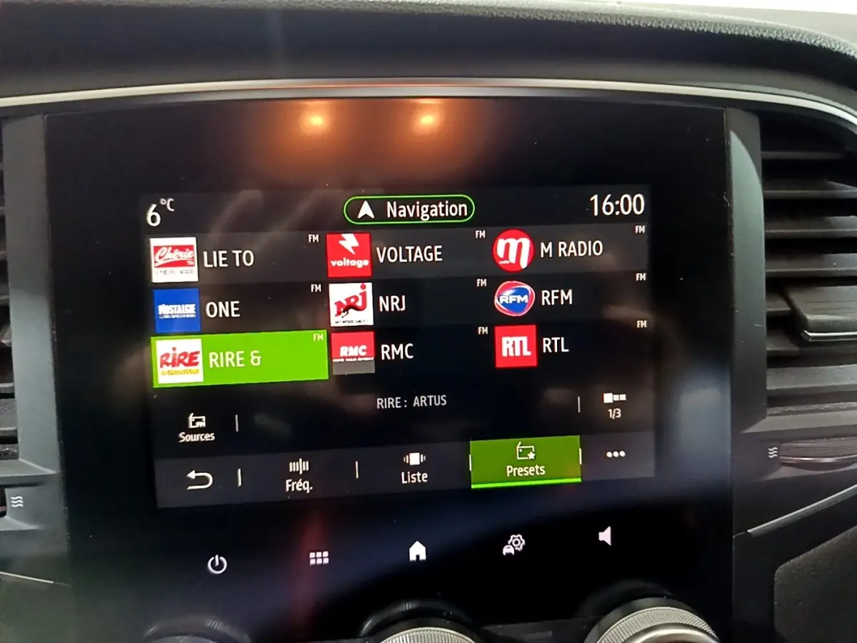 Écran tactile central de la Renault Mégane Business gris clair affichant les stations radio et la navigation à 16h.