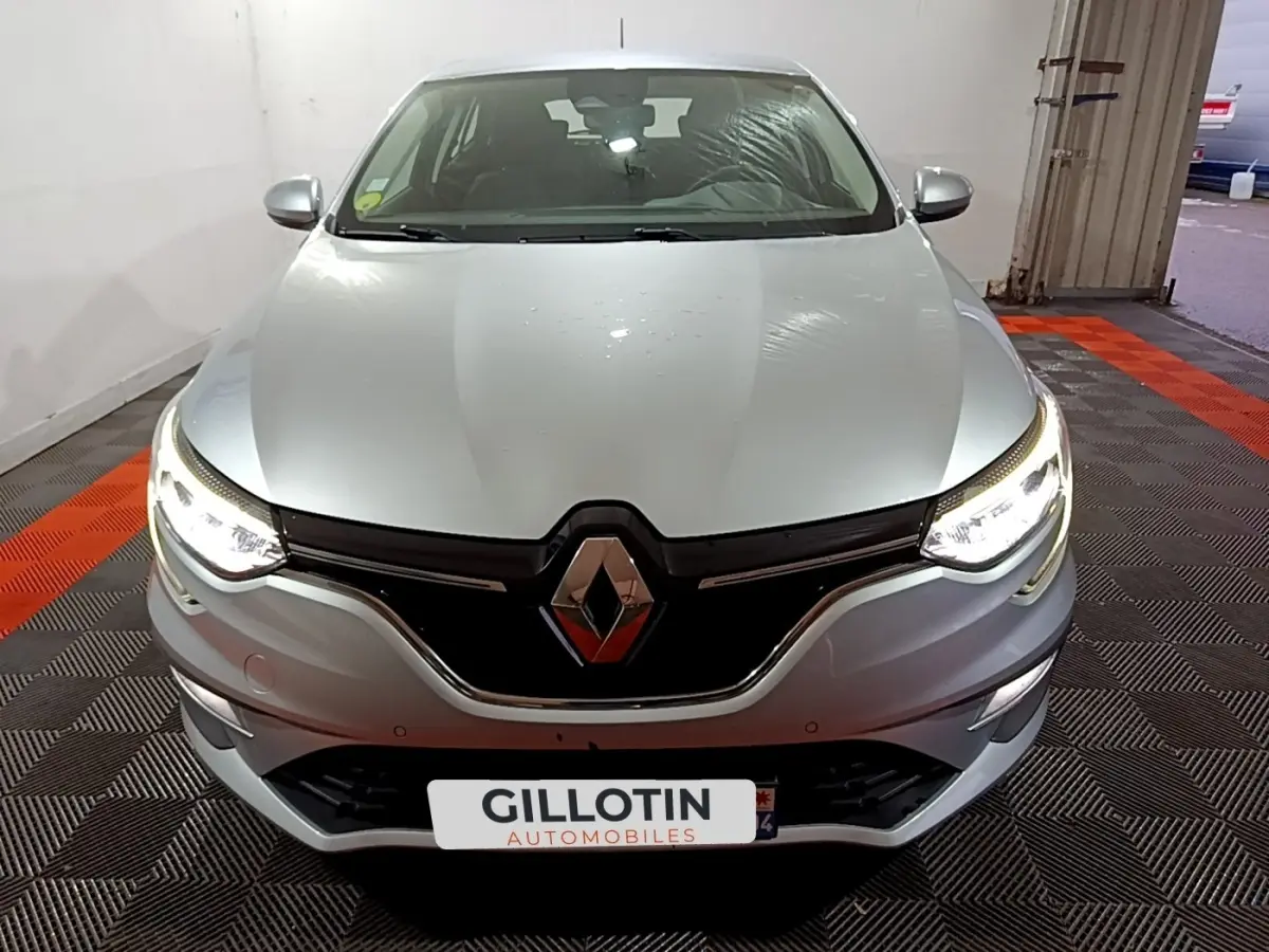 Vue avant d'une Renault Mégane Business Blue dCi 115 EDC gris clair avec phares LED allumés dans un garage.