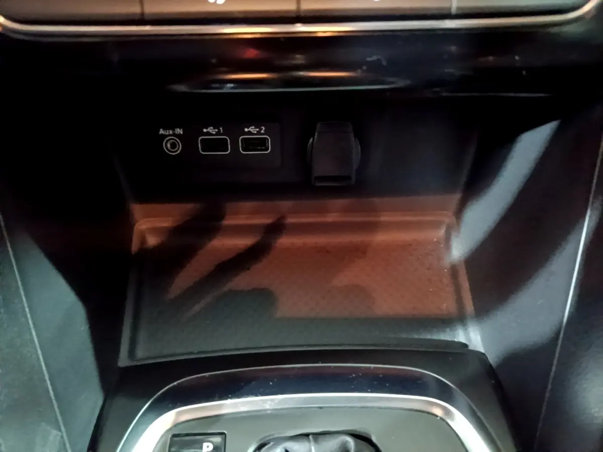 Gros plan sur la console centrale de la Renault Mégane Business gris clair, montrant les ports USB et prise auxiliaire.