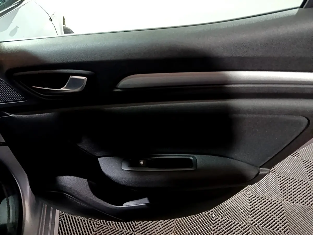 Vue intérieure côté droit de la porte avant gris clair de la Renault Mégane Business Blue dCi 115 EDC avec poignée argentée.