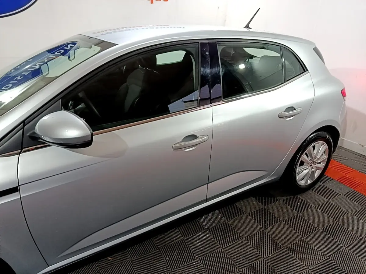 Vue latérale droite d'une Renault Mégane Business Blue dCi 115 EDC gris clair, avec poignées et rétroviseur assortis.