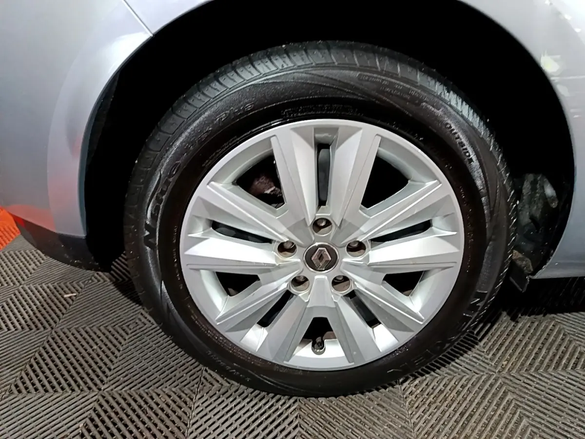 Gros plan sur la roue avant gauche grise d'une Renault Mégane Business Blue dCi 115 EDC avec jante alliage argentée.