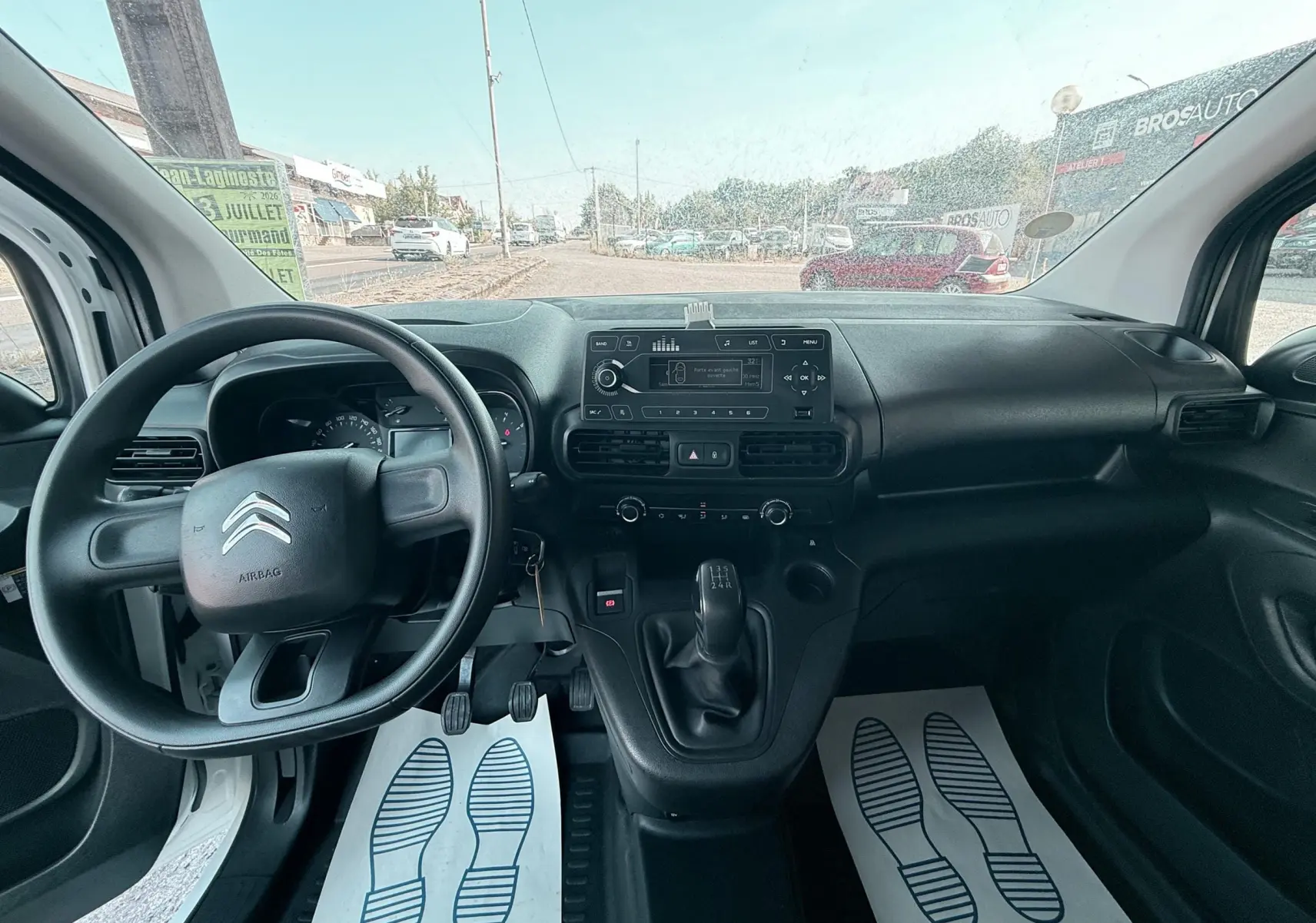 Vue intérieure du tableau de bord et volant du Citroën Berlingo blanc 2019, version 1,5 BHDI 75ch Club avec boîte manuelle.