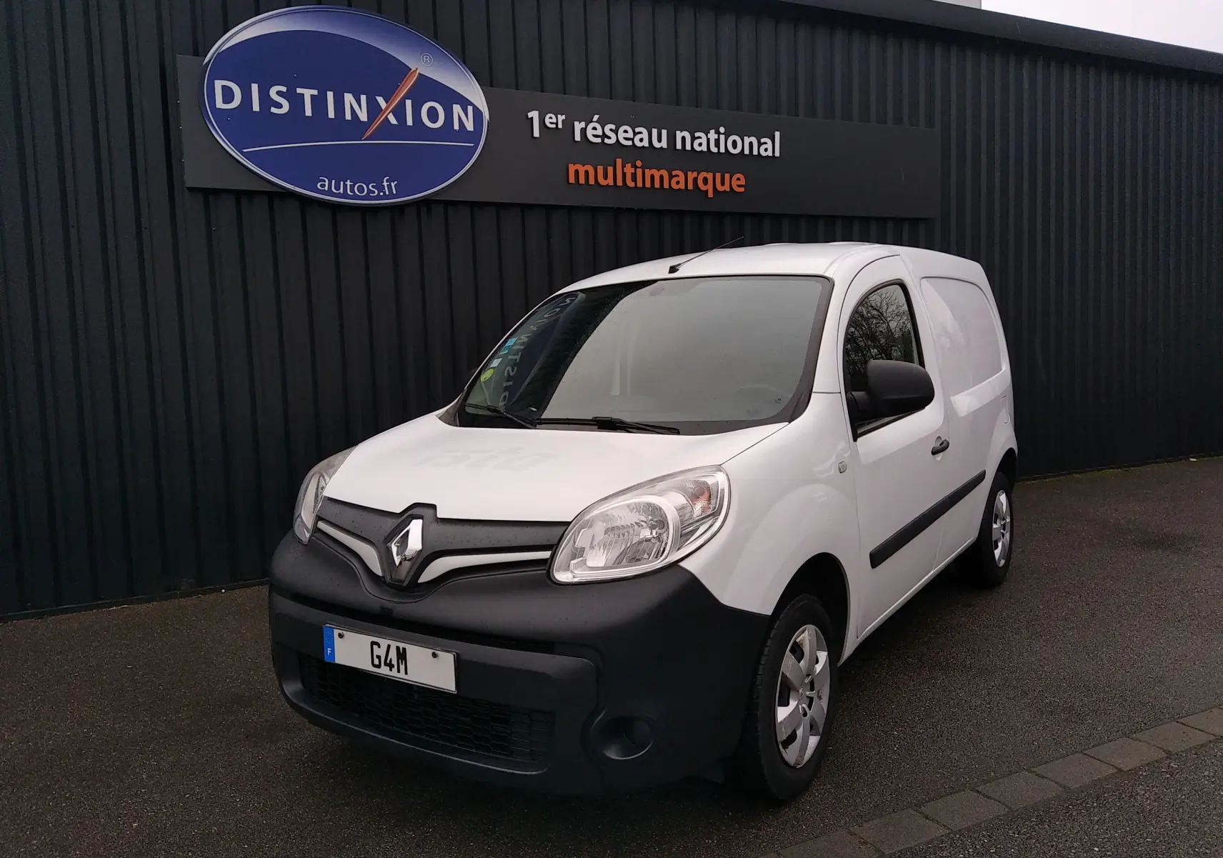 Renault Kangoo blanc 2019 en 3/4 avant droit, utilitaire compact avec pare-chocs noir mat et logo Renault visible.