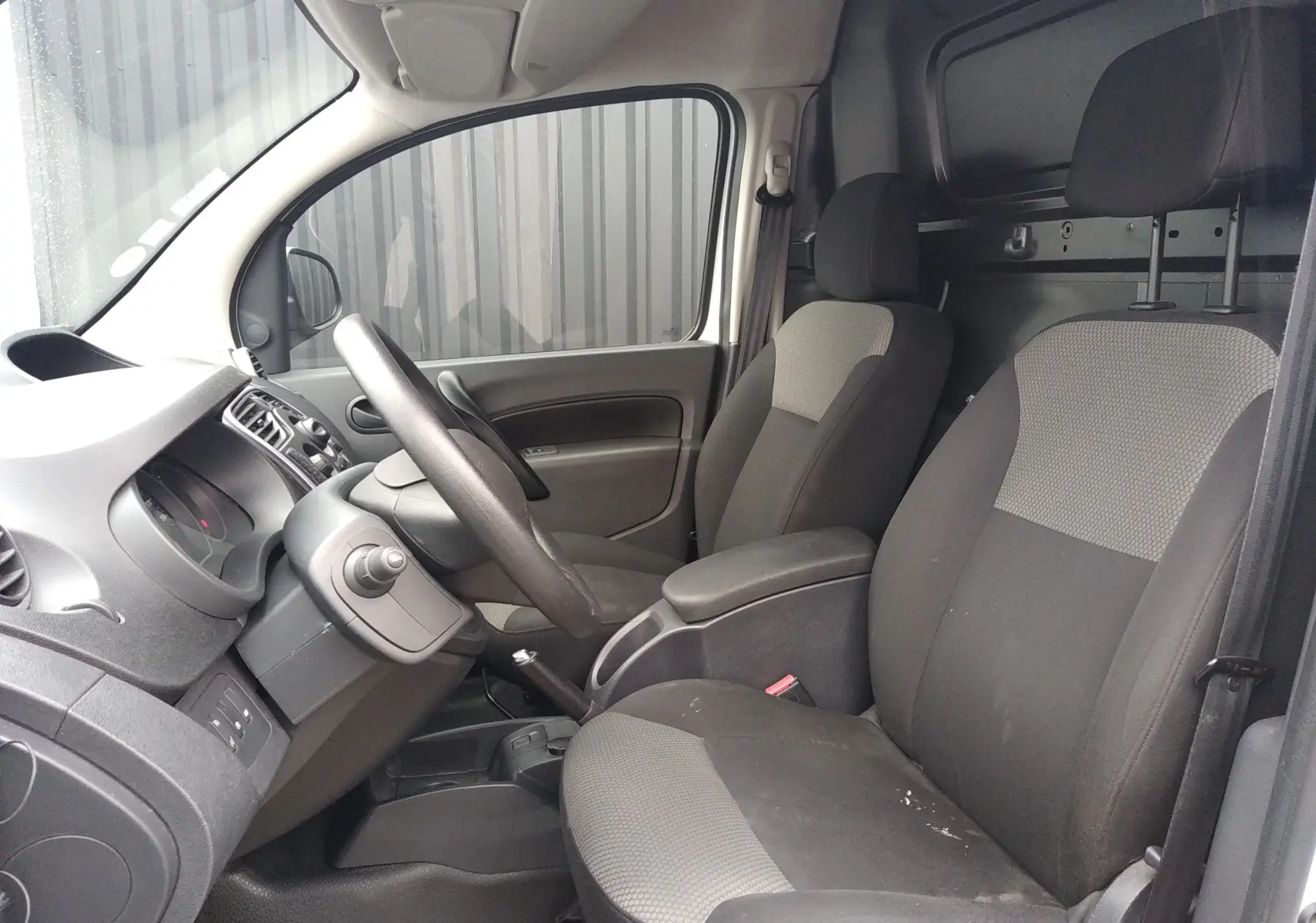 Intérieur du Renault Kangoo blanc 2019, vue côté gauche sur les sièges tissu et le tableau de bord simple.