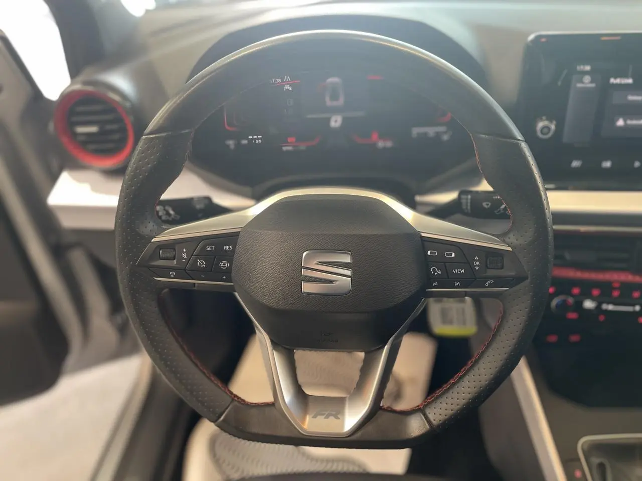Volant sport cuir multifonction avec logo SEAT et insert FR, vue frontale du poste de conduite du SEAT Arona 2024.