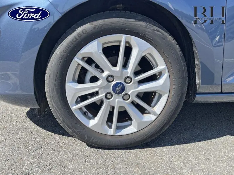Gros plan sur la roue avant gauche de la Ford Fiesta bleu azur métallisée avec jante alu 16 pouces Titanium Business.
