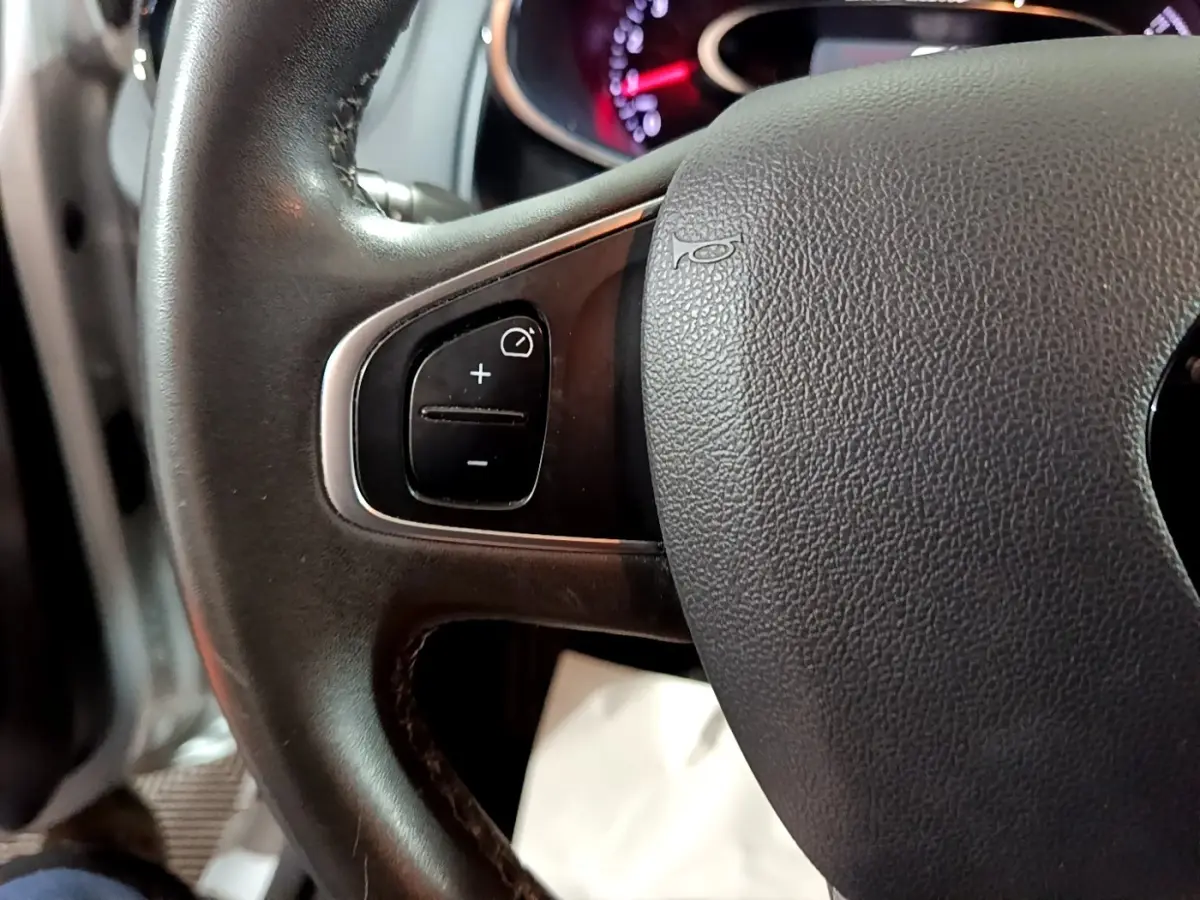 Gros plan sur le volant cuir multifonctions de la Renault Clio Business gris clair de 2018, avec commandes intégrées.