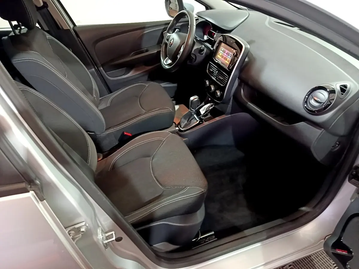 Vue intérieure côté conducteur d'une Renault Clio Business gris clair 2018 avec volant cuir multifonctions et écran tactile central.