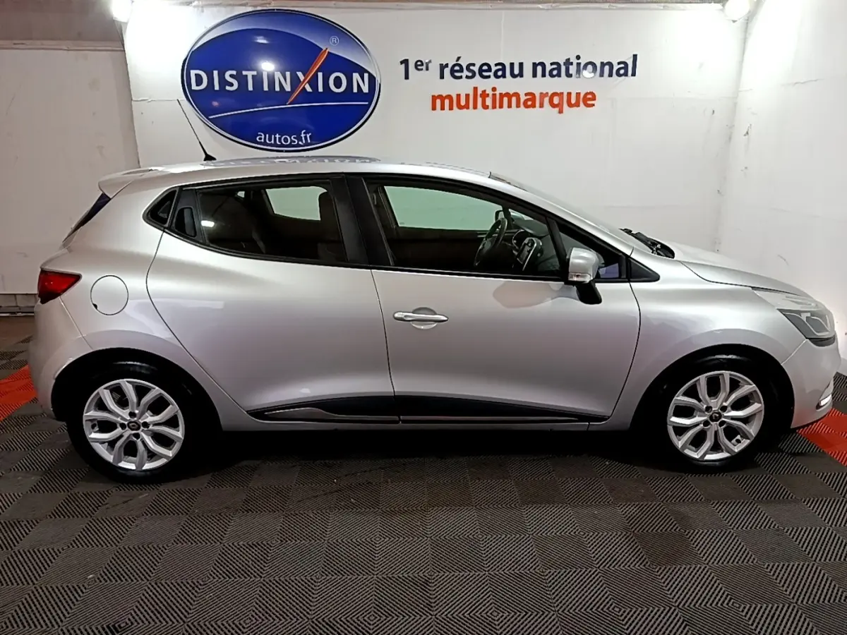 Profil droit d’une Renault Clio Business dCi 90 EDC gris clair 2018 en intérieur, avec jantes alliage et vitres teintées.