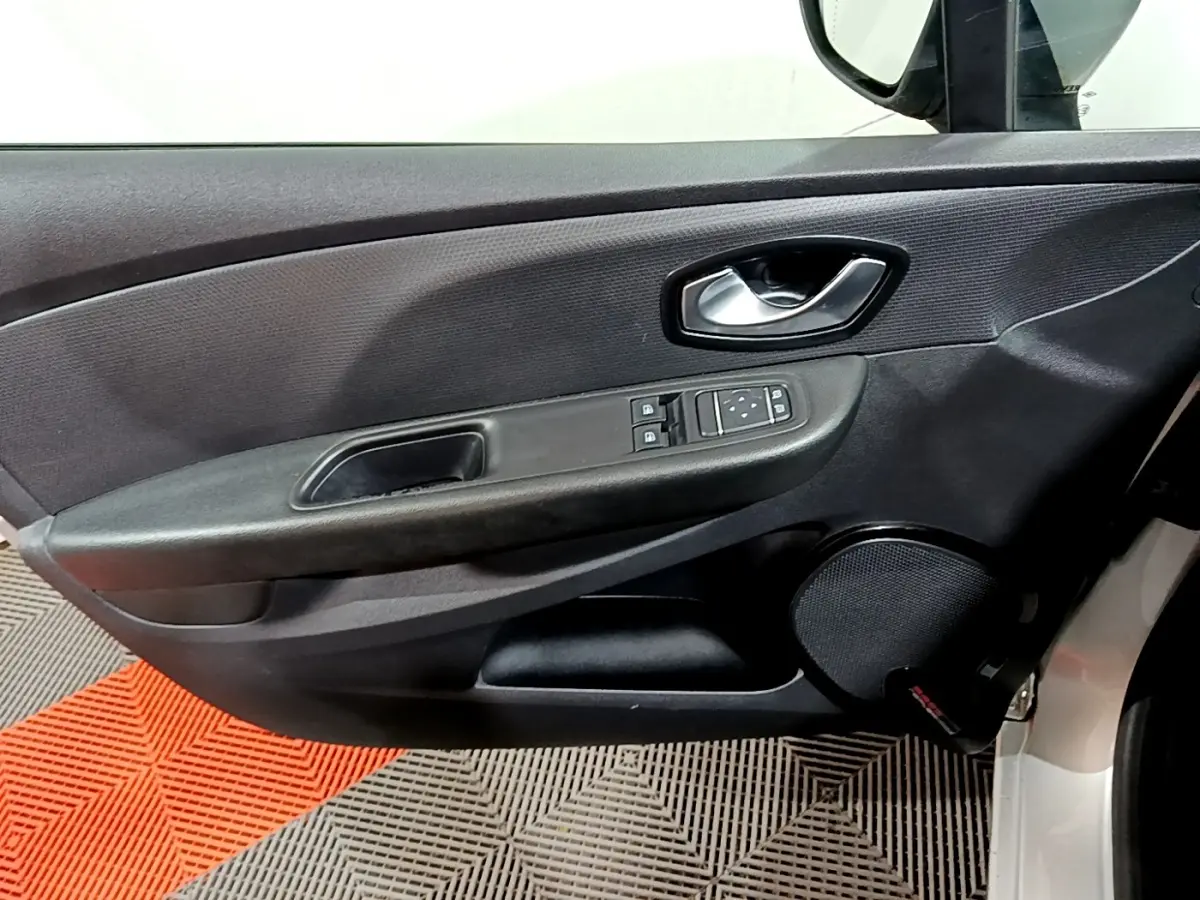 Vue intérieure du panneau de porte avant gauche gris foncé avec commandes des vitres et haut-parleur rond sur Renault Clio Business dCi 2018.