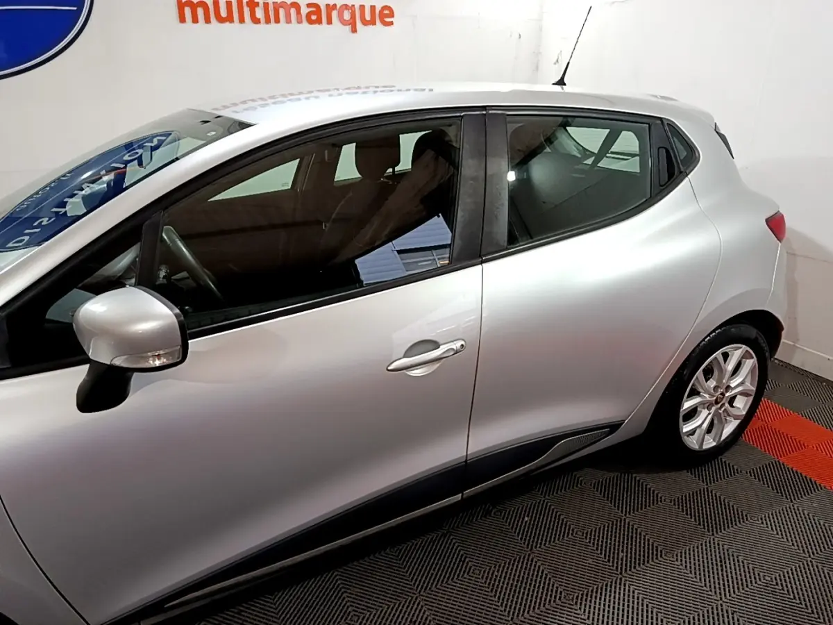 Profil côté gauche d'une Renault Clio Business gris clair de 2018, avec jantes alliage et rétroviseur assorti.