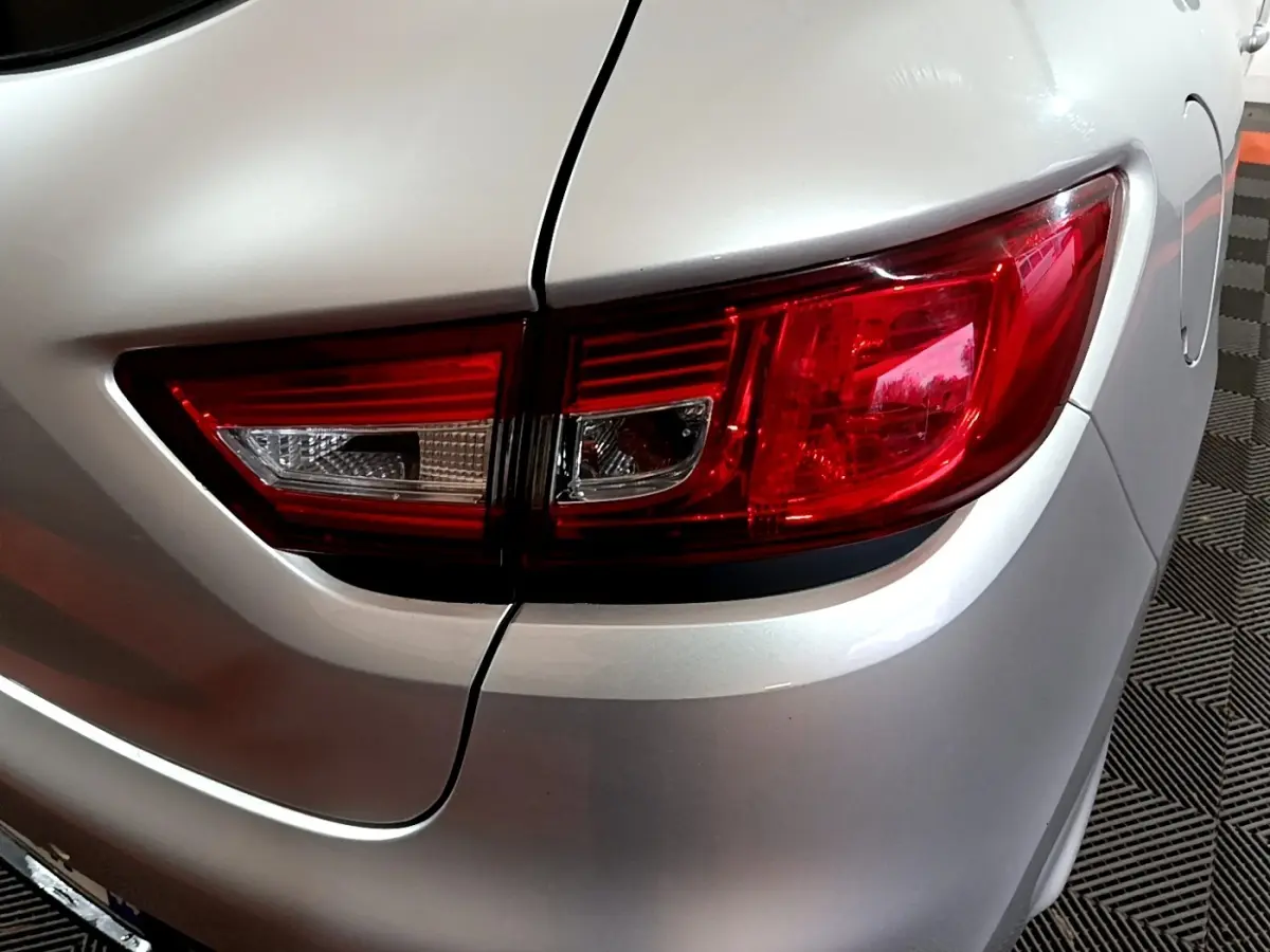 Gros plan sur le feu arrière droit d'une Renault Clio Business gris clair de 2018, détails nets et contours précis.