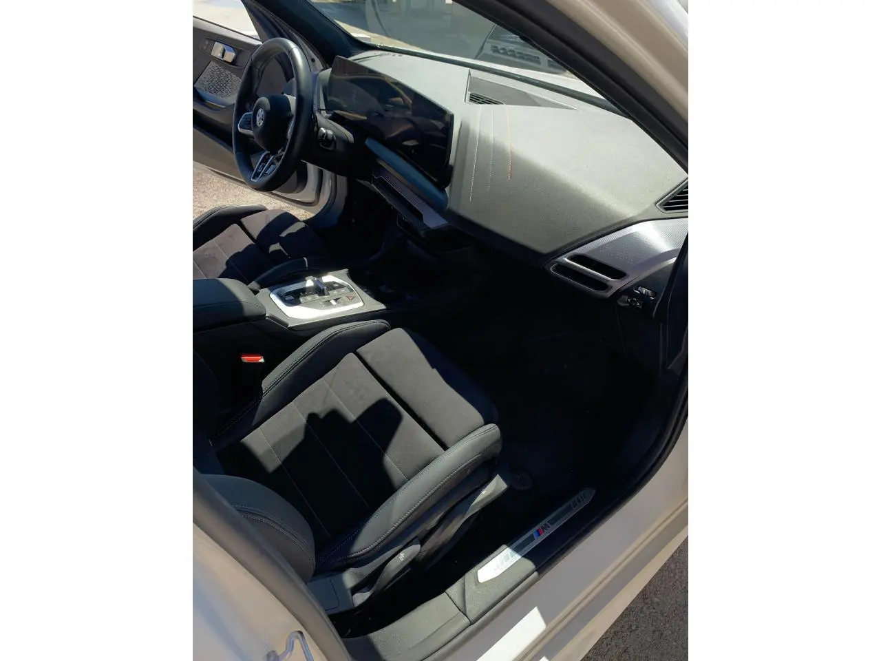 Intérieur côté conducteur BMW Série 1 118d M Sport 2025, sièges Alcantara noirs et tableau de bord moderne.