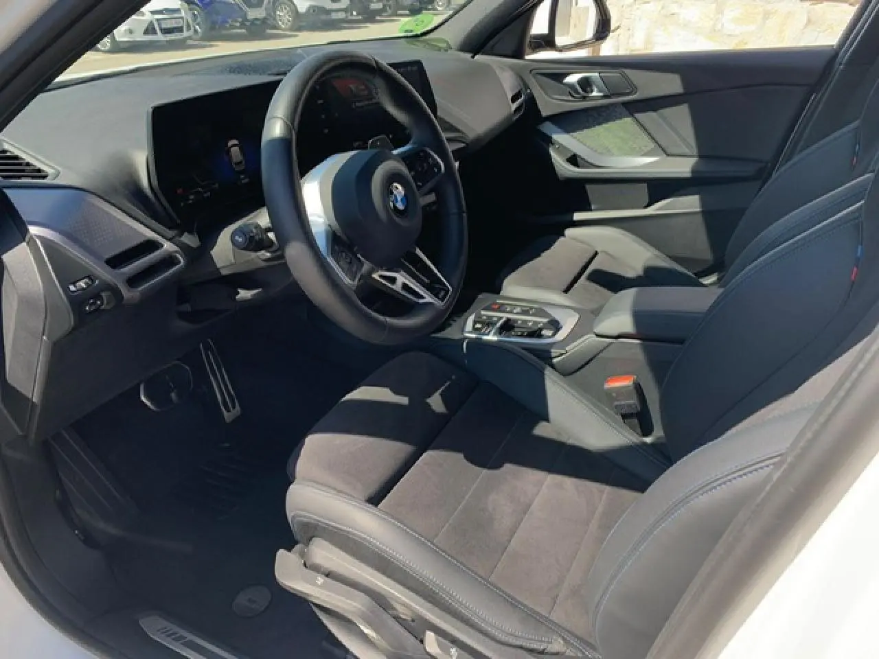Intérieur côté conducteur de la BMW Série 1 118d 2025 avec sellerie Alcantara noire et volant M cuir multifonctions.