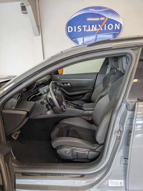 Vue intérieure côté gauche de la Peugeot 508 SW gris selenium 2024, sièges cuir noir et tableau de bord moderne