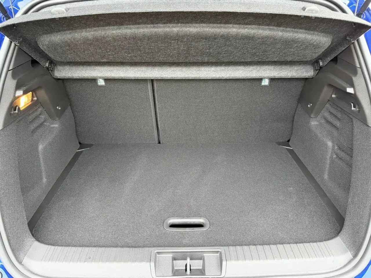 Coffre ouvert vu de l'arrière d'un Renault Captur Bleu Iron 2025, montrant l'espace de chargement vide.