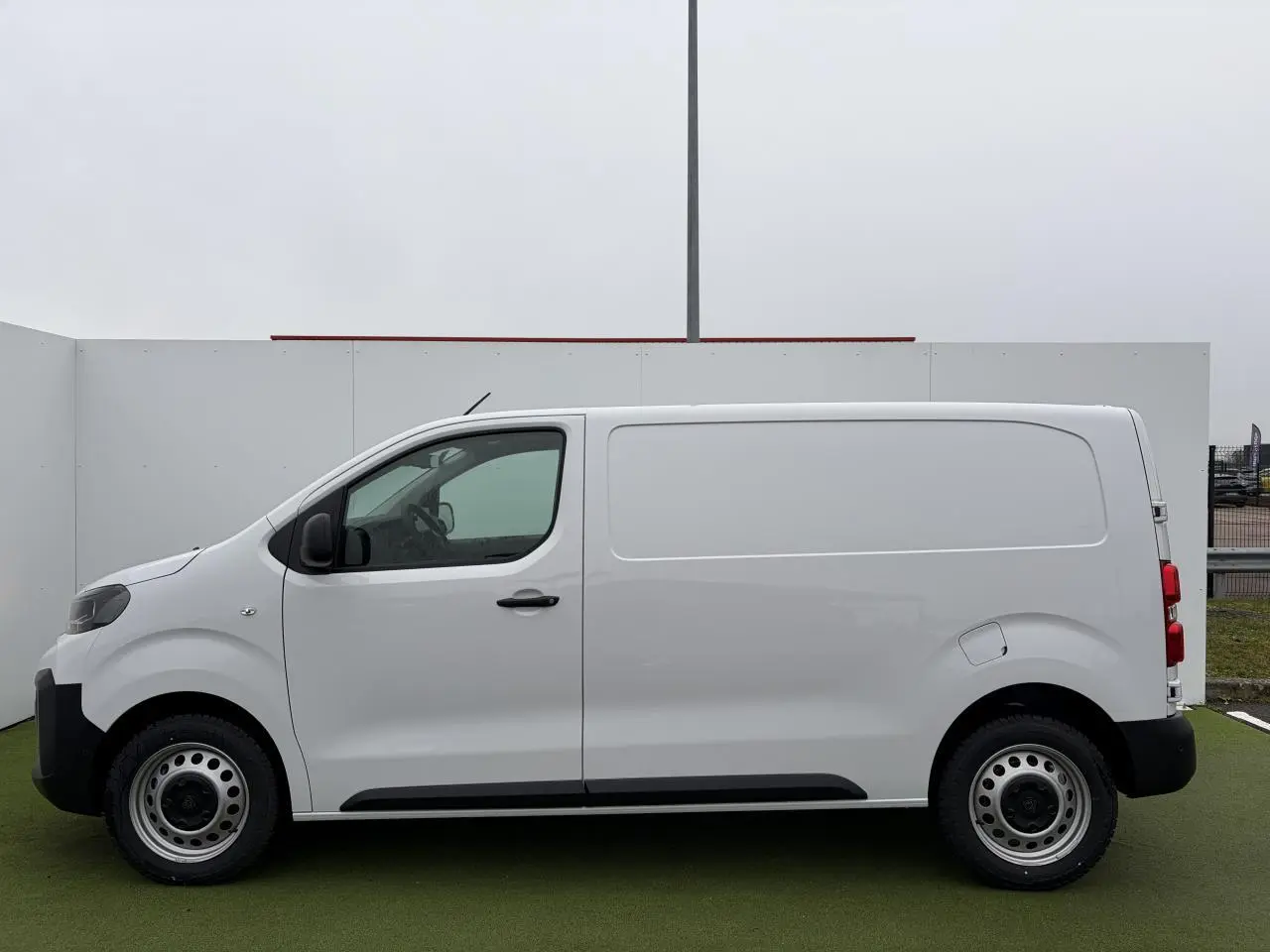 Vue de profil côté gauche d'un Peugeot Expert Fourgon blanc Icy avec jantes tôle 17'' grises et porte latérale coulissante.