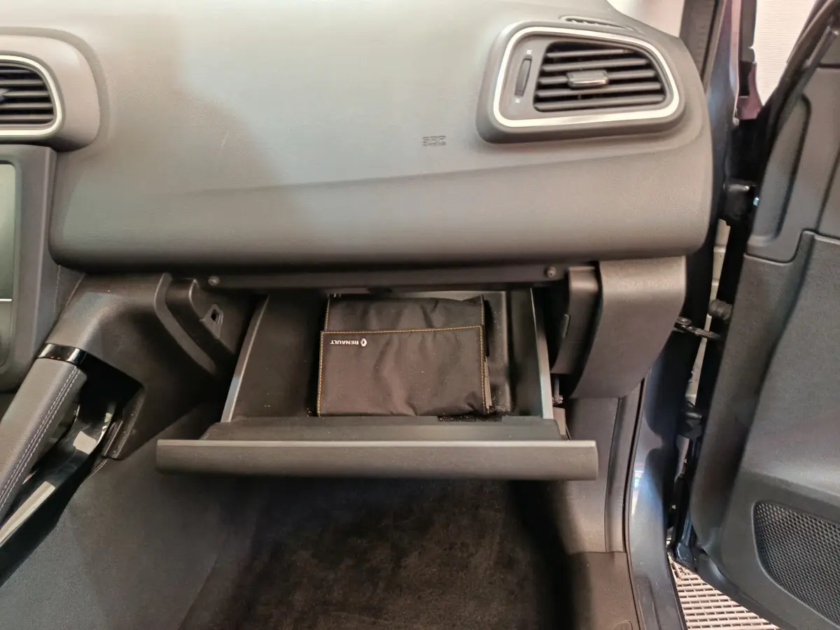 Vue intérieure du coffre à gants ouvert côté passager du Renault Kadjar Business gris foncé avec pochette noire visible.