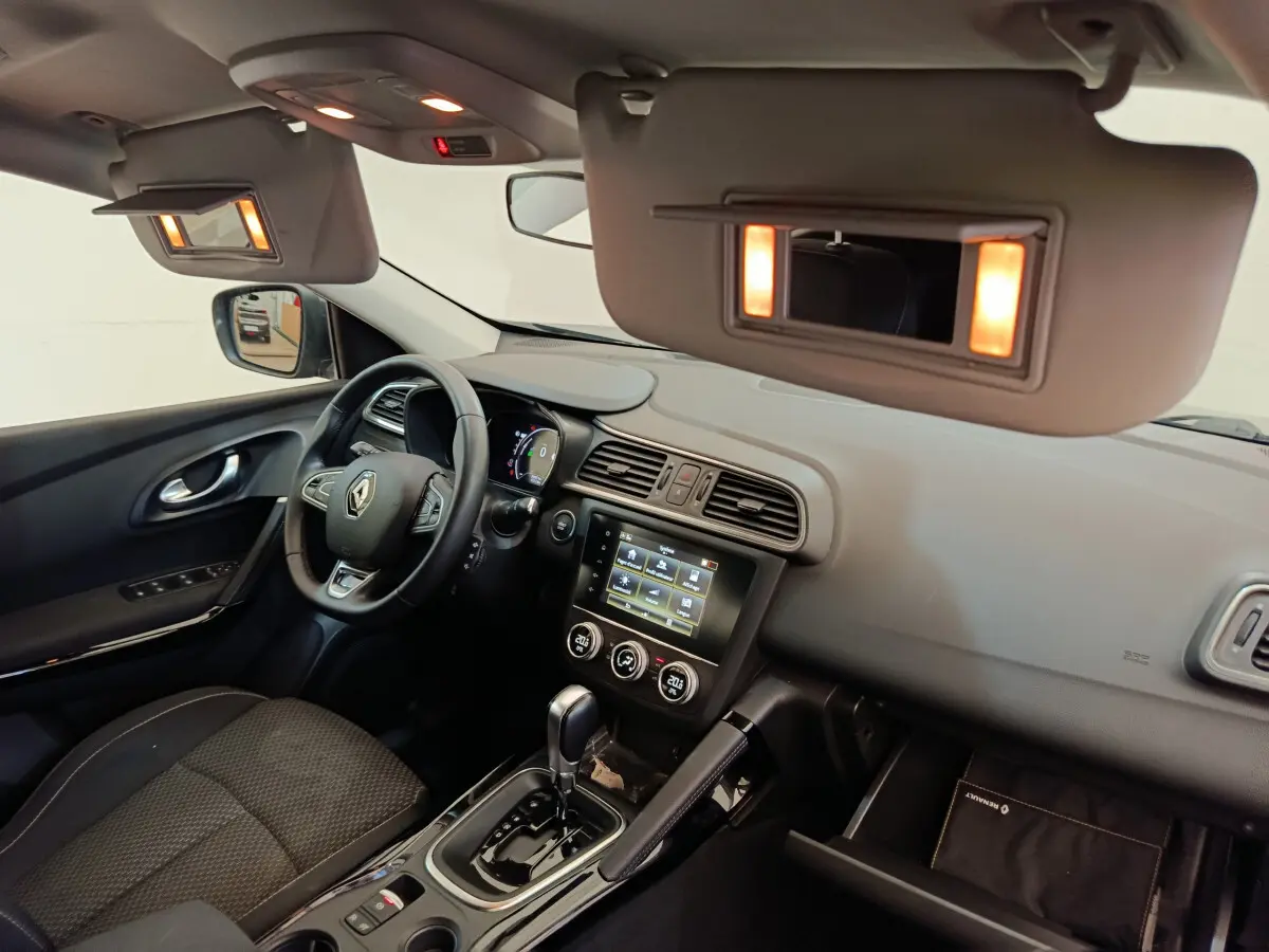 Intérieur avant droit du Renault Kadjar gris foncé 2022, tableau de bord avec écran tactile et volant multifonctions.