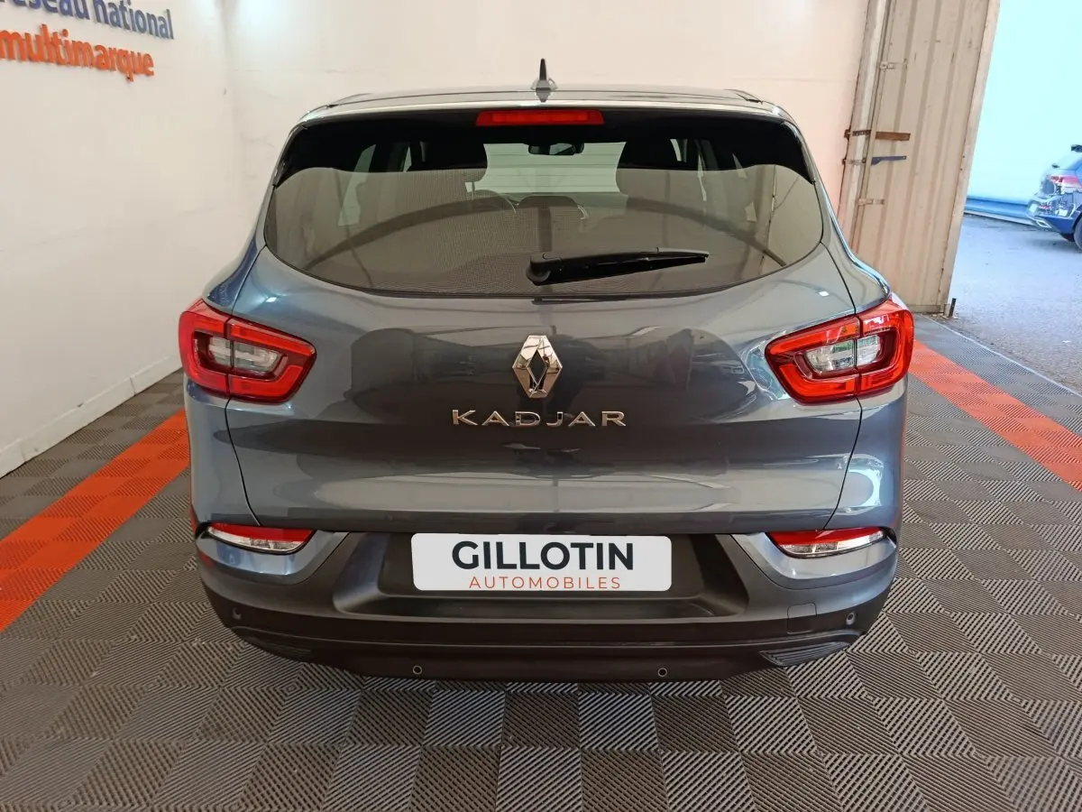 Vue arrière d'un Renault Kadjar gris foncé 2022 avec feux arrière rouges et logo central visible.